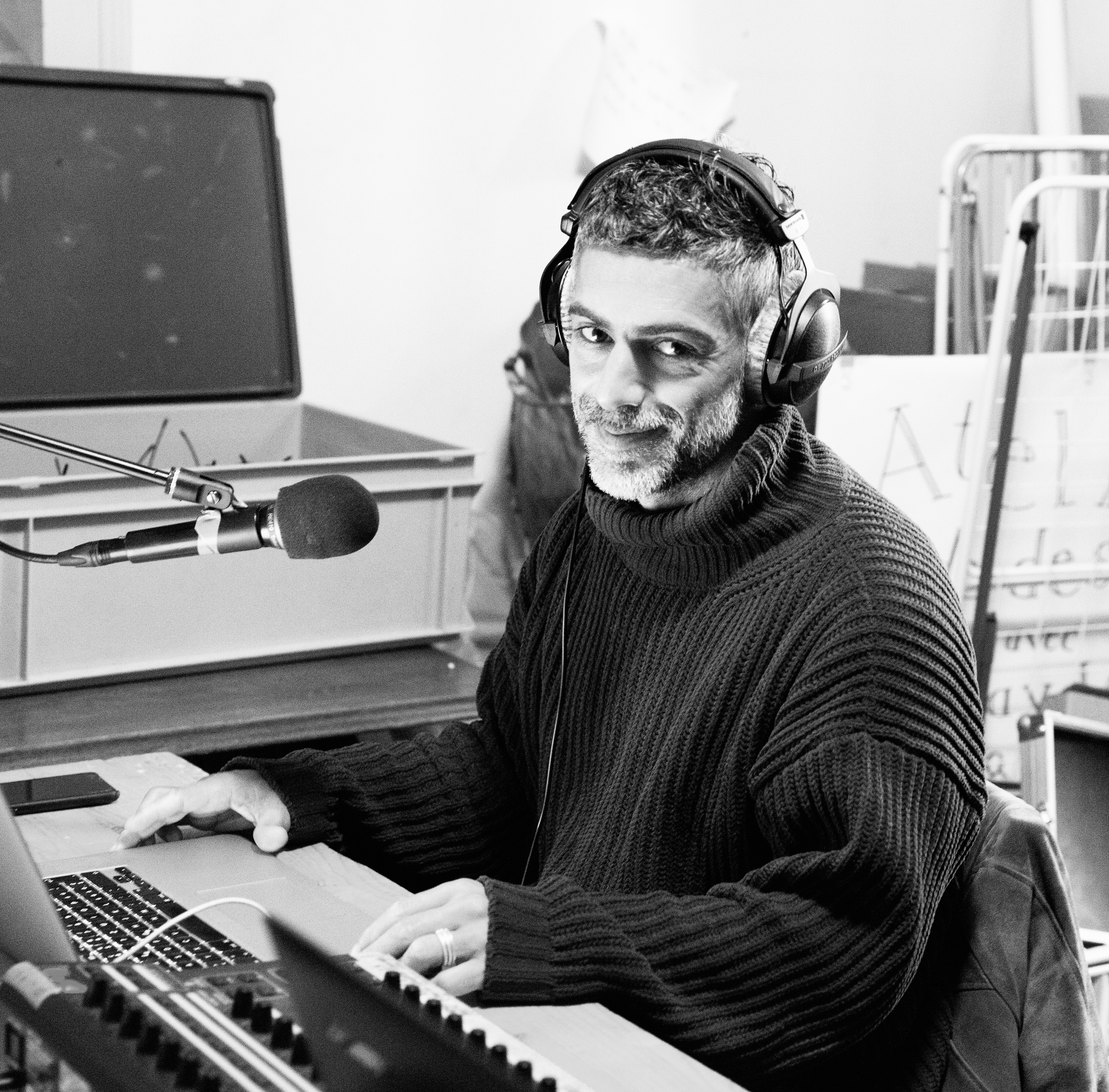 Portrait de Paolo Dos Santos, audiodescripteur, assis devant son ordinateur portable avec un casque sur les oreilles