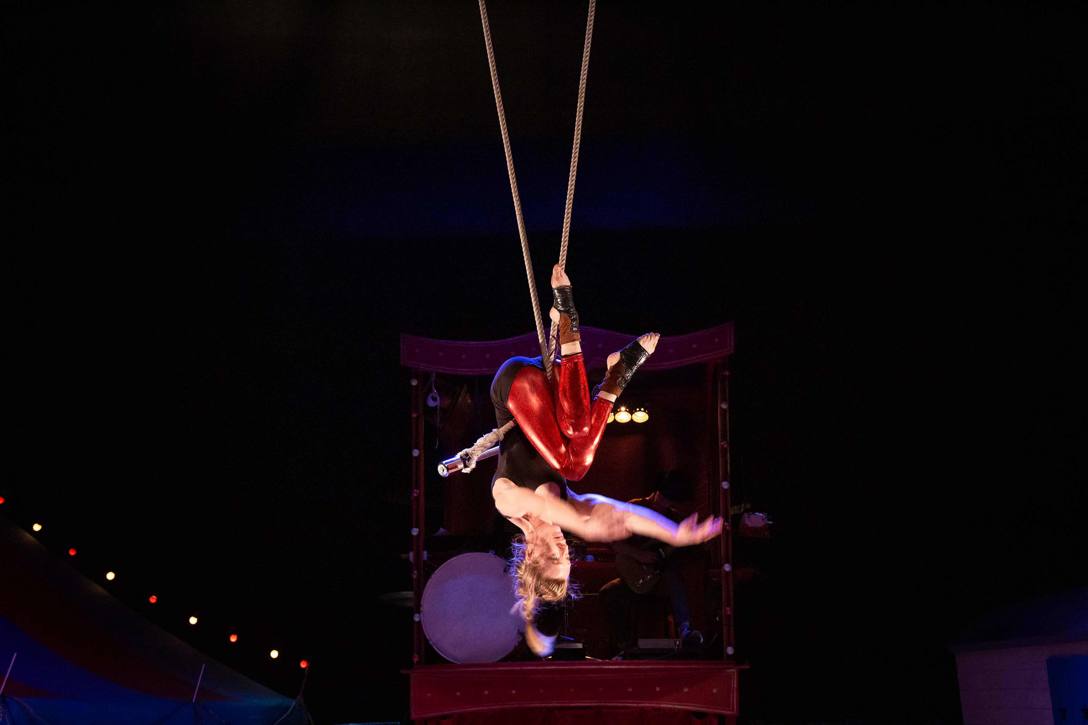Descriptif de l'image : 4 personnes se trouvent de part et d'autre d'une roulotte de cirque placée au centre de la scène.